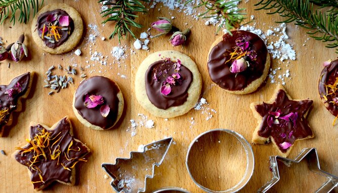 Jarolim Geschenke Kekse | © SONNENTOR Auf dem Foto sind weihnachtliche Kekse mit Schokoglasur und Blüten zu sehen. | © SONNENTOR